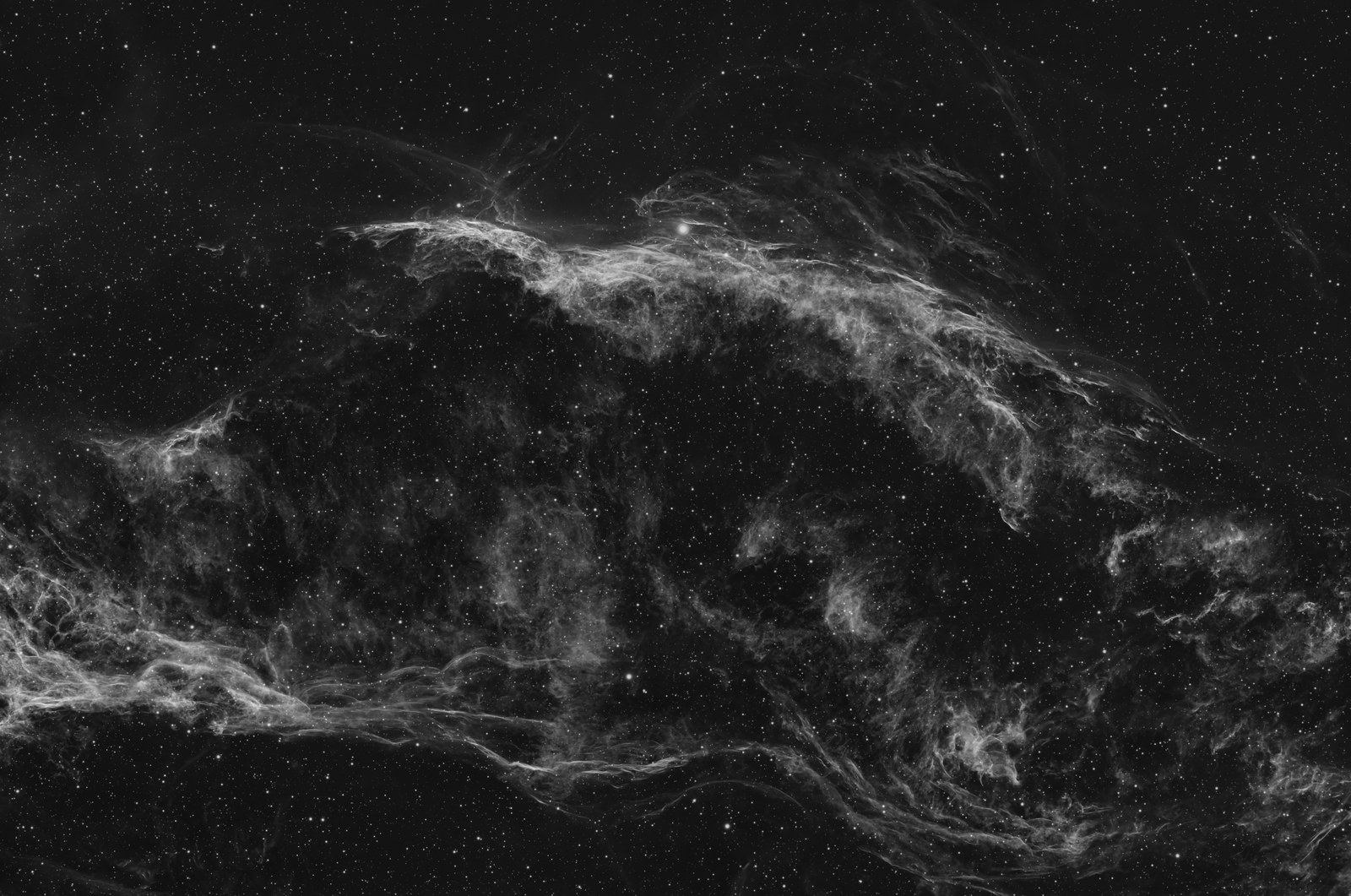 Westlicher Schleiernebel als Graustufenbild: helle Gasfäden auf schwarzem Himmel, ohne Farbe